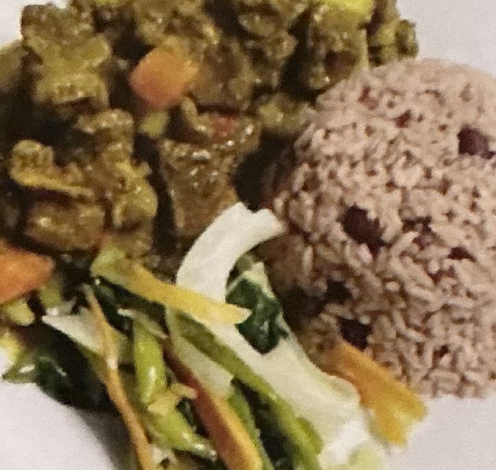 Curry goat with rice and beans and steamed vegetables